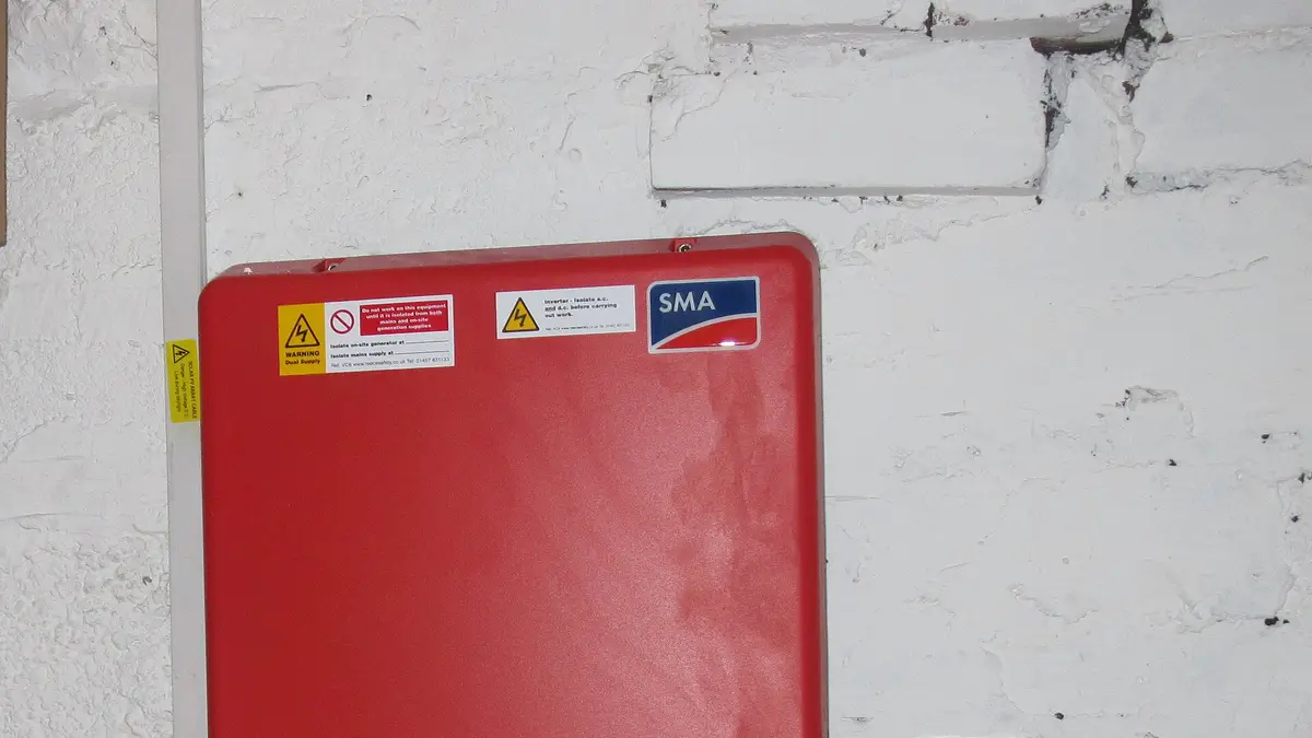 Inversor solar vermelho instalado em uma parede branca