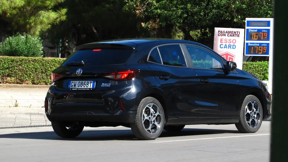 MG 3 Hybrid de color azul oscuro estacionado frente a una estación de servicio