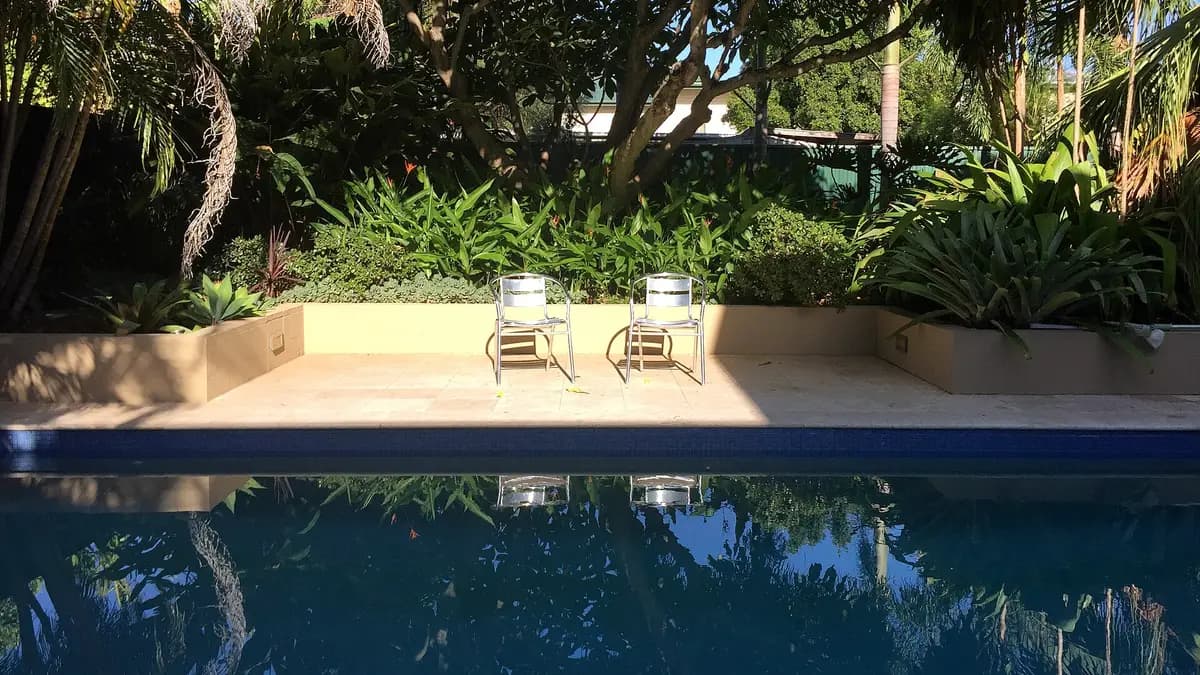 Piscina residencial com espreguiçadeiras na borda
