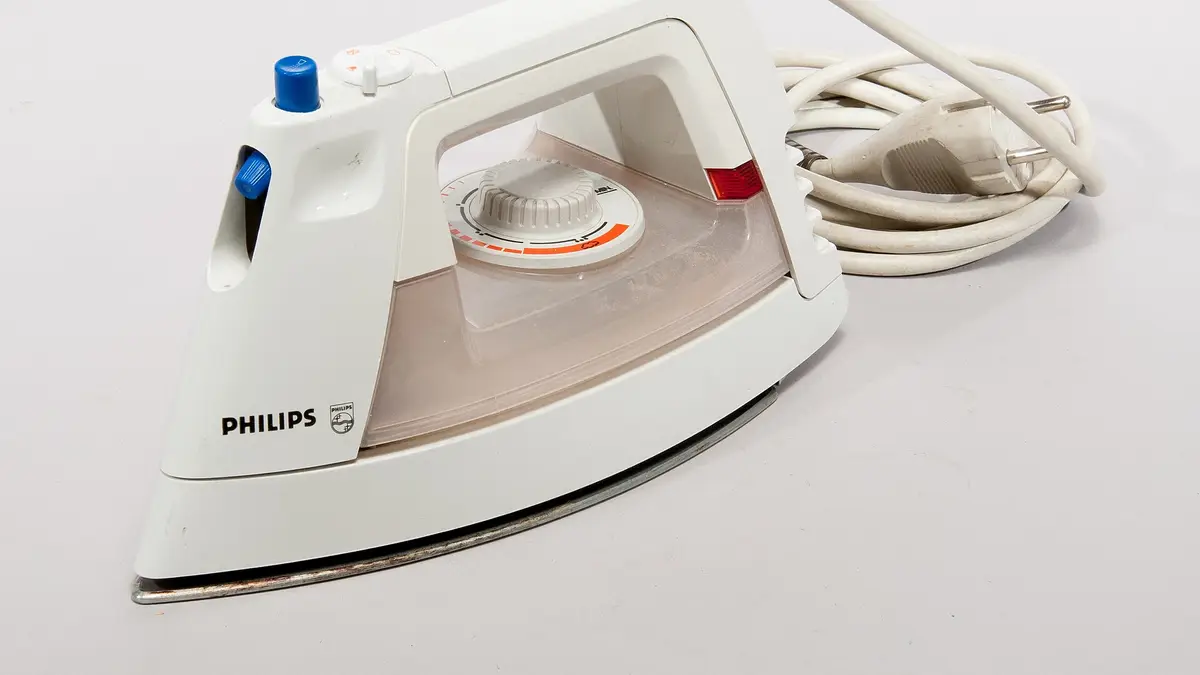 Plancha a vapor Philips blanca con su cable, sobre fondo blanco