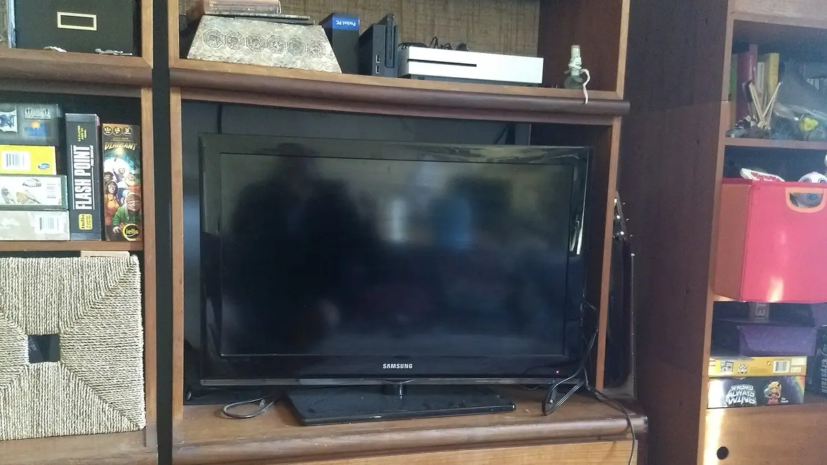 Televisor de pantalla plana sobre un mueble de madera con repisas