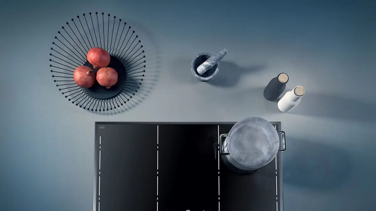 Black glass-ceramic cooktop with a pot seen from above in a kitchen